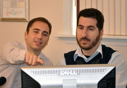 co-worker is pointing to another persons computer, but is not too close.