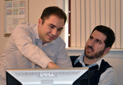 co-worker is leaning over another person's computer